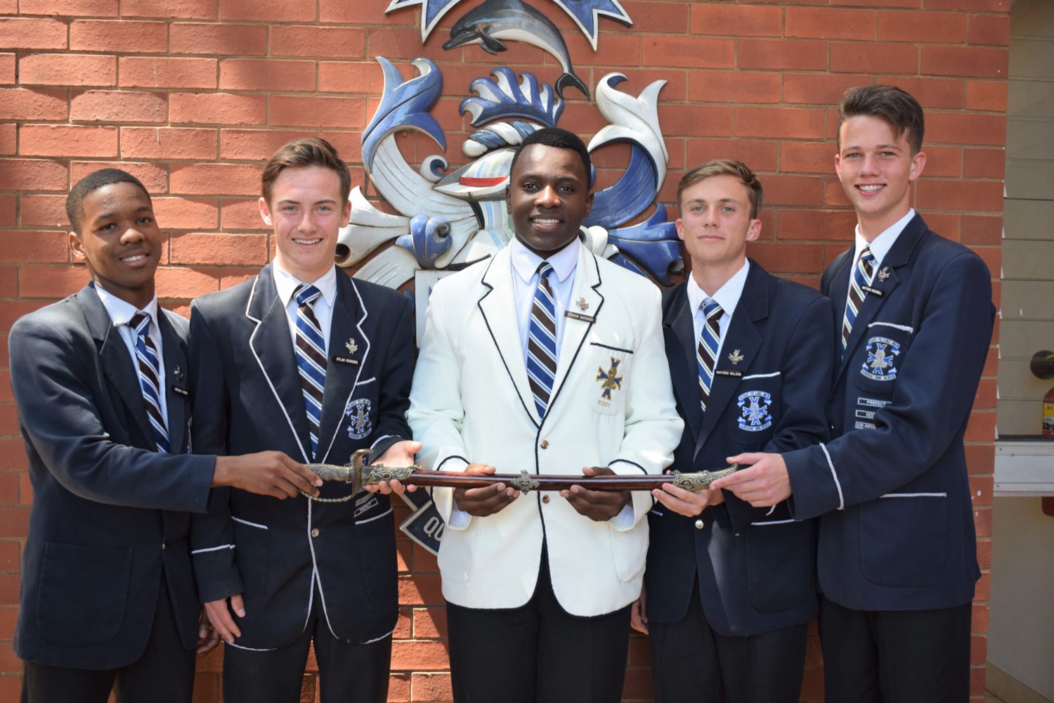 Northwood senior boys with the school sword in front of the crest